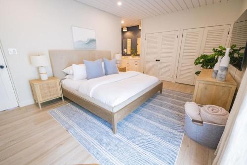 1 dormitorio con 1 cama con sábanas blancas y almohadas azules en Elevate USVI Completely remodelled 2025!, en East End