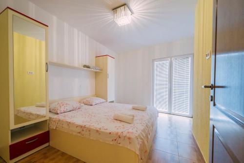 a small bedroom with a bed and a mirror at Luxur house with seaview teracce in Baška Voda