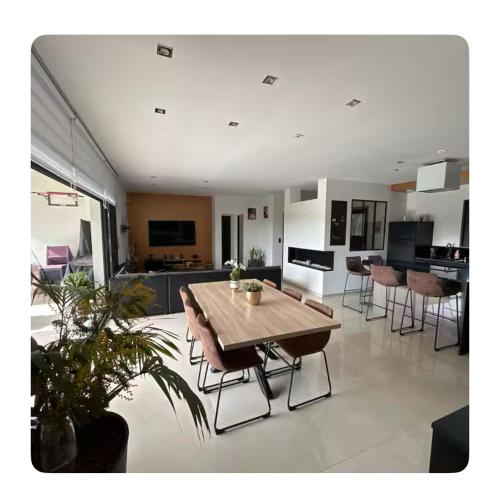 - un grand salon avec une table et des chaises en bois dans l'établissement Chambre dans Maison moderne tout confort, à Orgueil