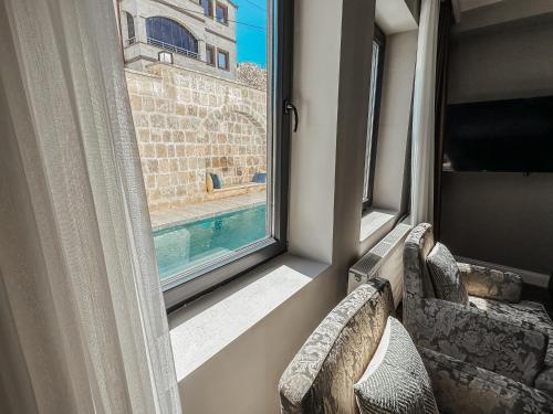 a window with a view of a swimming pool at Osmanli Cappadocia Hotel in Goreme