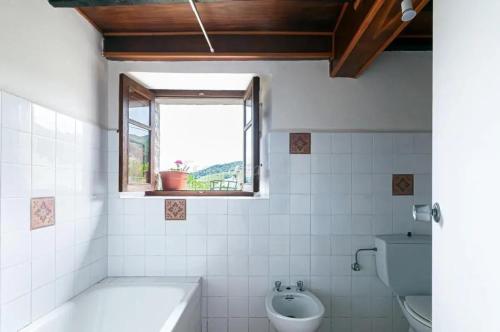 a bathroom with a tub and a toilet and a window at Cosy House in Isongo in Isongo