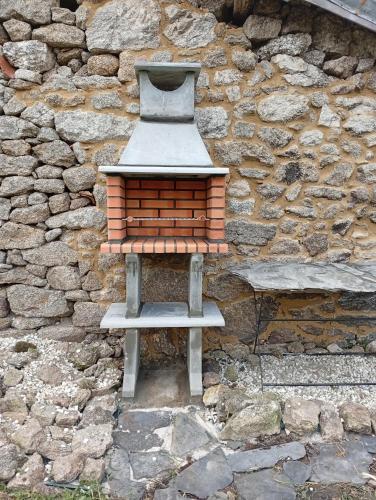 a bird feeder sitting in front of a stone wall at A casa da Penela in Sas de Penelas