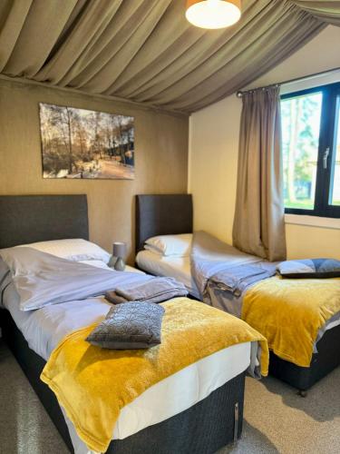 a bedroom with two beds and a window at Riverside Cabins in Shrewsbury