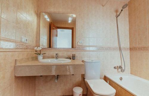 a bathroom with a sink and a toilet and a mirror at Blue Surf House in Corralejo