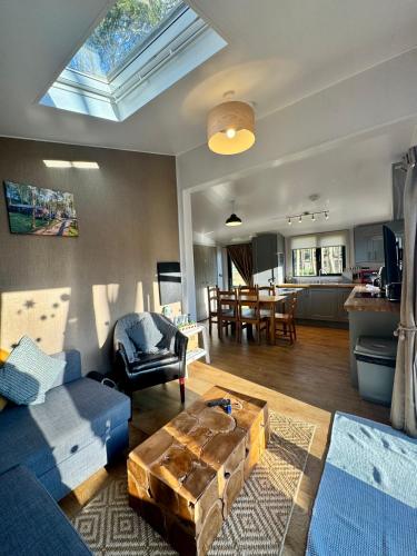 a living room with a blue couch and a table at Riverside Cabins in Shrewsbury