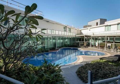 a building with a swimming pool in front of a building at Coastal Bliss 2 Bedroom Apartment in Gold Coast