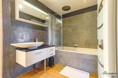 une salle de bain avec un lavabo et une baignoire dans l'établissement Le Loft - Hypercentre - Capitole - Clim, à Toulouse