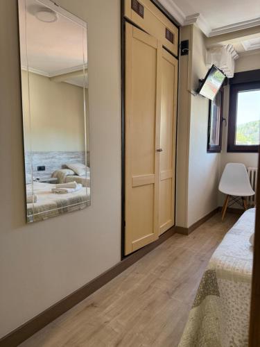 a bedroom with a door and a mirror at Pension Reconquista in Cangas de Onís