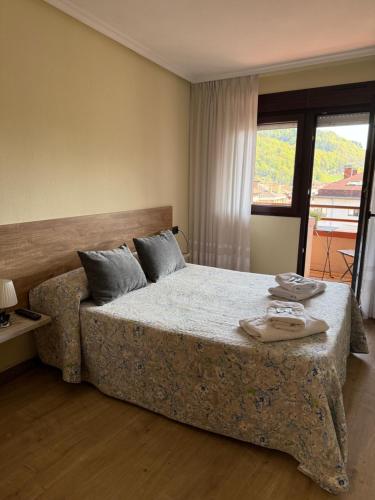 a bedroom with a bed with two towels on it at Pension Reconquista in Cangas de Onís