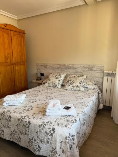 a bedroom with a bed with two towels on it at Pension Reconquista in Cangas de Onís