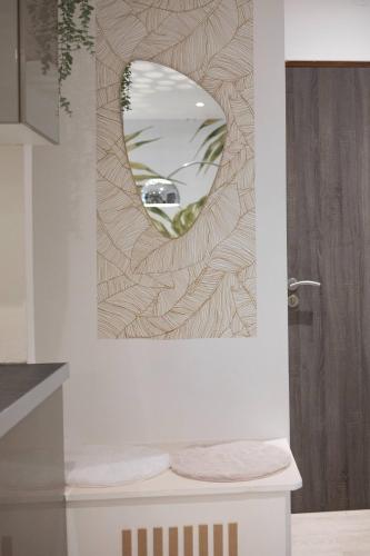 une salle de bain avec un miroir au mur dans l'établissement Le Marly - Hyper Centre Mulhouse, à Mulhouse