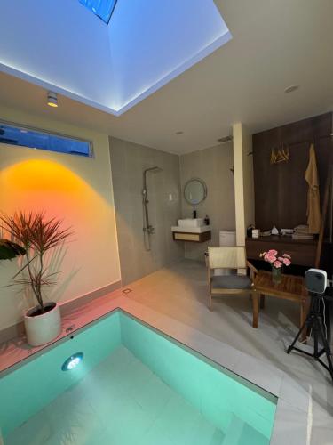 a living room with a swimming pool and a bathroom at Malis Homestay in Trà Vinh