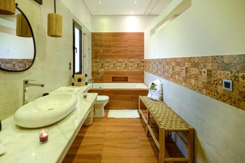 a bathroom with a sink and a tub and a toilet at Villa Alia - Piscine privée 3 Ch Navette Aéroport Gratuit in Marrakech