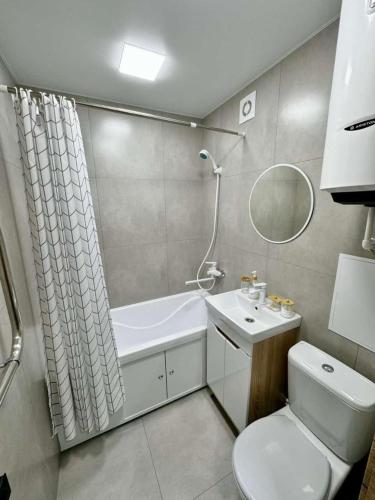a bathroom with a toilet and a sink and a mirror at Квартира 4-40 in Balqash