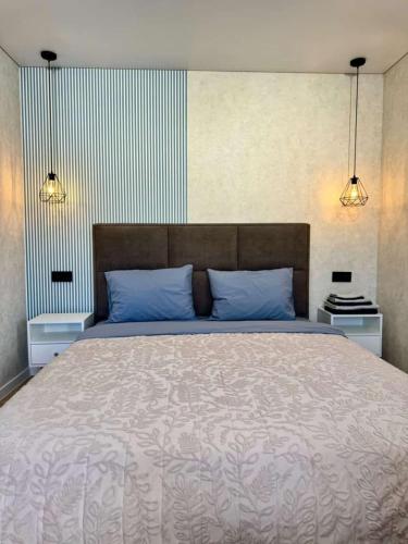 a bedroom with a large bed with blue pillows at Квартира 4-40 in Balqash