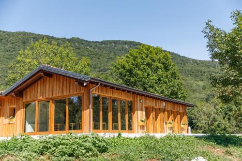 a wooden cabin with mountains in the background at Agriturismo Fattoria Carolina - Friuli Venezia Giulia - Val d'Arzino in Vito dʼAsio
