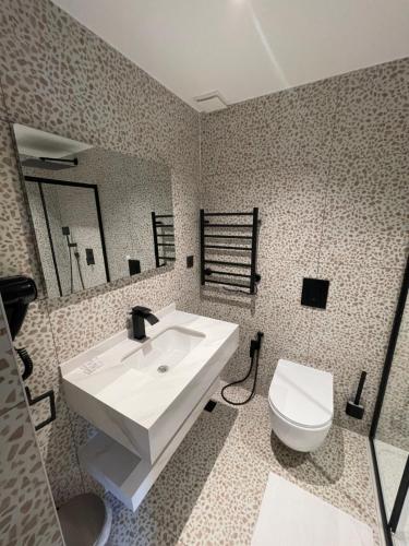 a bathroom with a white sink and a toilet at Rosemay Hotel near London Heathrow Airport in Hayes