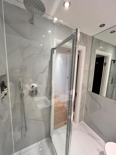 a shower with a glass door in a bathroom at Elegant 1 Bedroom flat near Harrods in London