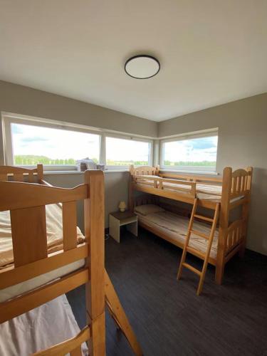 a room with two bunk beds and two windows at Mārtiņmāja in Saraiķi