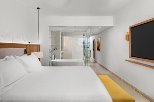 a bedroom with a large bed and a tv at DoubleTree by Hilton Sharks Bay Resort in Sharm El Sheikh