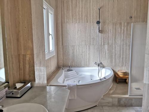 a bathroom with a tub and a toilet and a sink at La Luna Blanca in Torremolinos