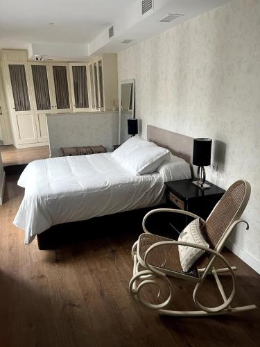 a hotel room with two beds and a chair at La casa del Retablo in Córdoba