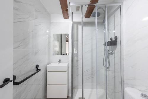 a white bathroom with a shower and a sink at Alcoy Old Town - Reformed Penthouse with AC and wifi in Alcoy