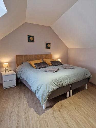 a bedroom with a large bed in a attic at Maison de charme avec jardin au bord de l'Eure in Le Vaudreuil