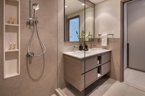 a bathroom with a shower and a sink and a mirror at Bella Elite Homes at Grande Signature Burj and Fountain Great Full View- Brand New Luxury Apartement in Dubai