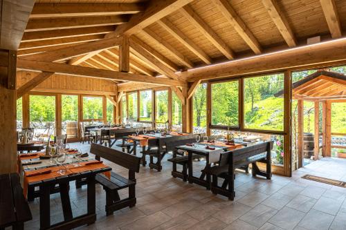 a large dining room with wooden tables and windows at Agriturismo Fattoria Carolina - Friuli Venezia Giulia - Val d'Arzino in Vito dʼAsio