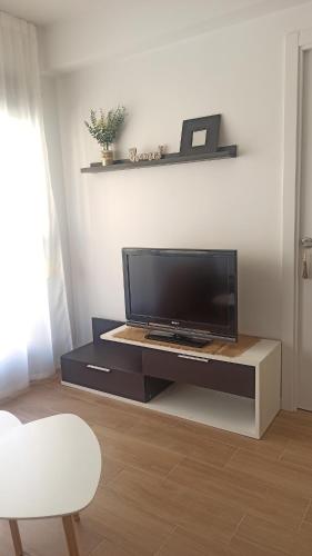 a living room with a flat screen tv on a entertainment center at Apartamento Murales de Talavera in Talavera de la Reina