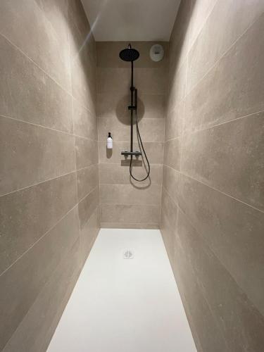 La salle de bains est pourvue d'une douche avec une lumière sur le mur. dans l'établissement COSY TERRASSE 6 pers Ax Thermes Centre Parking, à Ax-les-Thermes