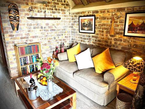 a living room with a couch and a brick wall at Ingwenya View in Marloth Park