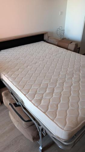 a mattress on a bed frame in a room at Cosy T2 refait à neuf climatisé, vue mer avec terrasse et jardin, Wifi piscine tennis et parking in Sète