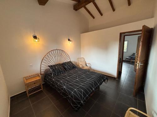 - une chambre avec un lit et une couette noire dans l'établissement cASAPIANA 7, à Porto-Vecchio