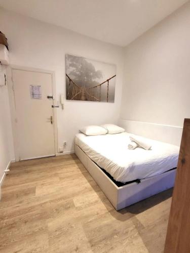 une chambre avec un lit et un tableau au mur dans l'établissement St Rome - A 2 pas du Capitole - Métro, à Toulouse