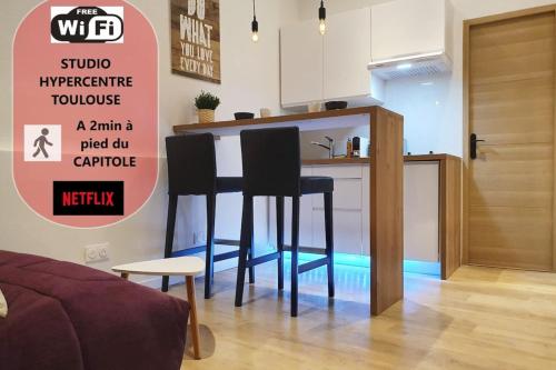 - une cuisine avec deux tabourets de bar noirs dans une pièce dans l'établissement St Rome - A 2 pas du Capitole - Métro, à Toulouse