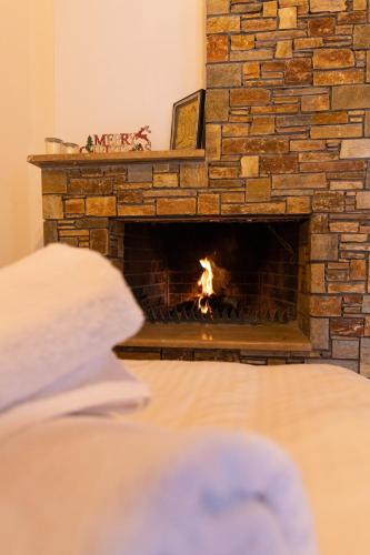 a brick fireplace with a fire in it at The courtyard house in Dhimínion