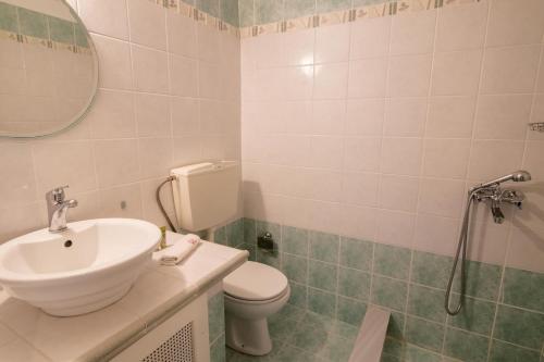 a bathroom with a sink and a toilet and a mirror at The courtyard house in Dhimínion