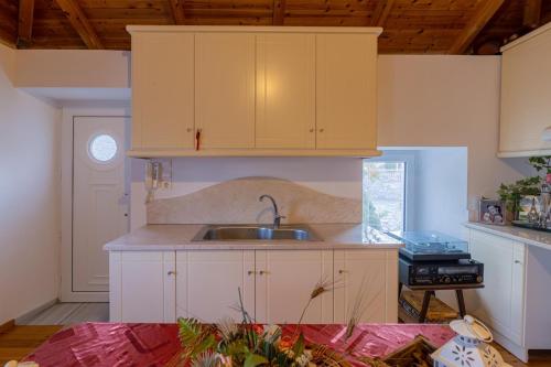 a kitchen with white cabinets and a sink at The courtyard house in Dhimínion