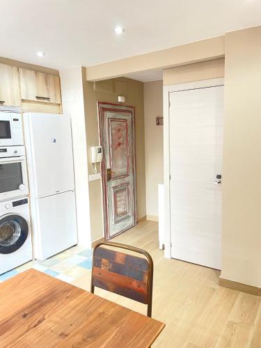 a room with a kitchen with a refrigerator and a door at Soleado 2 in Gijón