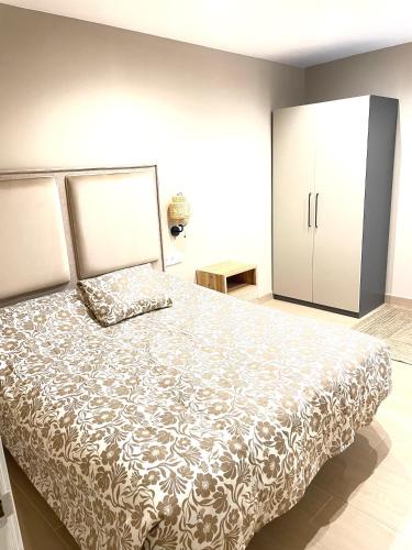 a bedroom with a large bed and a cabinet at Soleado 2 in Gijón