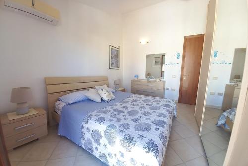 a bedroom with a blue and white bed and a mirror at Casa House Villa Chiara in Pula