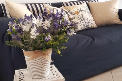 a vase of flowers on a table next to a couch at Casa House Villa Chiara in Pula