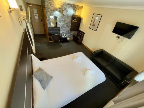 una camera con letto bianco e un soggiorno di Epsilon Hotel a Londra