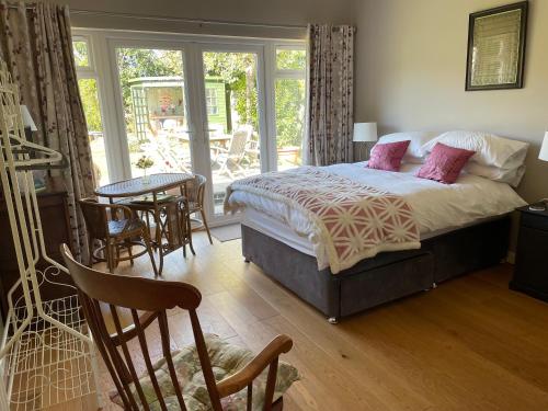 a bedroom with a bed and a table and chairs at Garden Room in Derby
