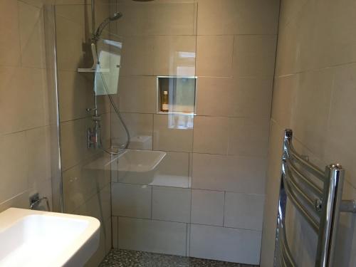 a bathroom with a sink and a toilet and a shower at Garden Room in Derby