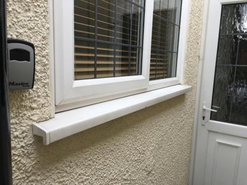 a window with a white sill next to a door at Garden Room in Derby