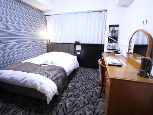 a hotel room with a bed and a desk at APA Hotel Hikoneminami in Hikone