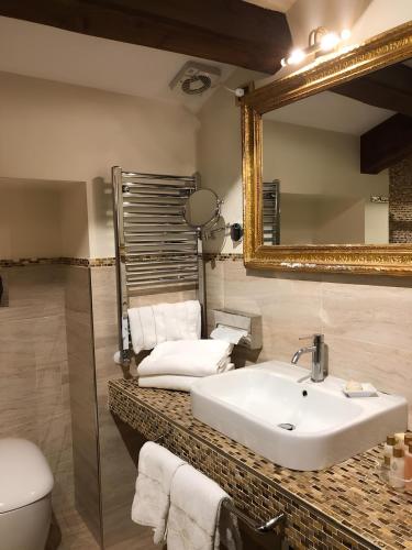 a bathroom with a sink and a mirror and a toilet at Casa Savoia & Casa Jolanda in Venice